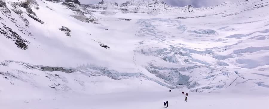 A roped line of climbers on the glacier
